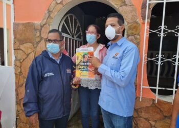 Viceministro de Obras Públicas Juan Ramírez junto al alcalde Luis Reyes haciendo entrega de la titularidad de tierras.